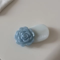 Détail d'une pince à cheveux camélia bleu clair aux pétales scintillants sur base blanche - Bleu Scintillant