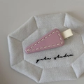 Detailed macro view of purple triangle hair clip with white stitching on quilted fabric - Pink with Yellow Trim
