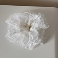 Nahaufnahme eines weißen Spitzen-Scrunchies mit mehrlagigen Rüschen und hohlen Spitzenkanten - Reinweiß Spitze - Taillenkreis