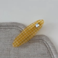 Gros plan sur une pince à cheveux à carreaux jaunes avec un strass brillant en cœur - Pince Ovale / Jaune