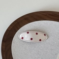 Détail d'une pince à cheveux ovale en tissu à pois rouges avec bords cousus fins - Beige Red Dot