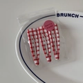 Three-piece red and white checkered hair clip set packaged in a clear bag on a plate - Red Bold Gingham Style