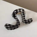 Détail d'une pince à cheveux à carreaux avec design ondulé et fini transparent - Style Ondulé