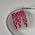 Close-up of three red and white polka dot metal hair clips in transparent packaging - Red Polka Dot Style