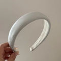 Close-up of a white padded sponge headband with a glossy finish and non-slip inner lining - Gray