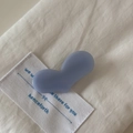 Détail d'une pince à cheveux minimaliste violet clair en forme de cœur sur tissu blanc - Style Cœur Bleu Clair