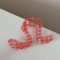 Detail of wavy hair claw clip with classic red and white gingham pattern and gold spring - Wave Geometric