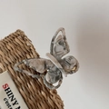 Detailed macro view of the acetate butterfly clip with elegant marble grey textures - Grey-Beige
