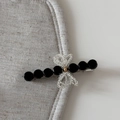 Close-up of elegant hair claw clip with black faceted beads and a woven bead bow - Beaded Bow Barrette