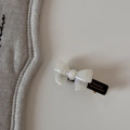 Detailed close-up of a pearly white bow hair clip with France Handmade gold lettering - Bobby Pin / White