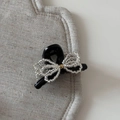 Close-up of black hair claw clip featuring a handcrafted clear beaded bow with golden bead - Small Beaded Bow Claw Clip