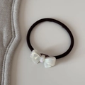 Gros plan d'un élastique à cheveux noir avec un nœud en résine nacrée blanche élégant - Cravate à cheveux / Blanc