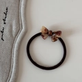 Détail d'un nœud en acétate écaille de tortue marron sur un élastique à cheveux noir - Cravate à cheveux / Caramel