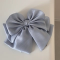 Detailed view of large light blue satin bow hair claw clip with multi-layered silk texture - Gray