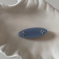 Detailed view of an oval blue matte hair clip with delicate rhinestone flower accents - Blue