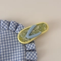 Makroaufnahme einer kreativen Flip-Flop Haarklammer aus gelbem und grünem Acetat mit Blumen - Grün