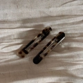 Detail view of acetate tortoiseshell hair clips on soft fabric with handmade texture - Hollow Out Clip Pair / Tortoiseshell