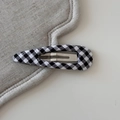 Detail of a black and white gingham fabric-covered BB hair clip on a textured mat - Plaid Waterdrop BB-Black White