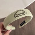 Close-up of LUCKY and Beautiful Girl embroidery on green padded sponge headband - Light Green