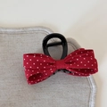 Dettaglio del fermaglio per capelli con fiocco rosso a pois e base nera lucida - Pinza per Capelli Media