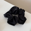 Detailed view of the glossy black satin oversized scrunchie with layered ruffle texture - Black