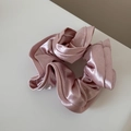 Detailed close-up of pink satin scrunchie with soft ruffled texture and silky shine - Pink