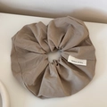 Dettaglio dell'elastico per capelli in tessuto tortora con etichetta tessuta handmade - Scrunchie / Marrone