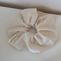 Dettaglio dell'elastico in raso crema che mostra la trama e l'etichetta Made in Korea - Scrunchie / Bianco Sporco