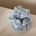 Détail d'un chouchou en organza bleu clair à pois blancs et bords à volants - Bleu