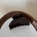 Gros plan d'une pince à cheveux brillante sur lin dans une boîte à bijoux en bois - Marron