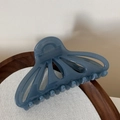 Detailed macro view of the blue hollow fan-shaped hair claw clip on a wooden tray - Dark Blue