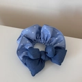 Dettaglio di elastico blu con motivo a stelle e fiocco in denim su fondo bianco - Stella di Denim