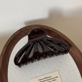Detailed view of large fan-shaped hollow hair claw in glossy dark chocolate resin finish - Brown