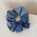 Dettaglio di un elastico per capelli a righe blu con un fiocco in tessuto coordinato - Stile Striscia Denim
