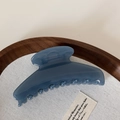 Detail of Morandi blue hair claw clip on wooden tray showcasing glossy finish and sleek curve - Dark Blue