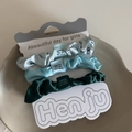 Dreiteiliges Satin-Haargummi-Set in Silber, Blau und Grün auf einer weißen Displaykarte - Blau-Grüne Kombination