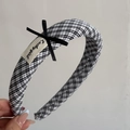 Detail of checkered plaid headband with a Luckygirl label and black ribbon bow accent - Black Plaid Hairband