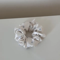 Detailed view of cream satin scrunchie with blue hearts and a silver round charm - Small Heart White