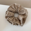 Dettaglio di scrunchie in rete beige con eleganti motivi a strisce marroni e consistenza - Marrone