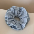 Macro shot of light blue striped mesh fabric and soft pleated texture of the large scrunchie - Blue