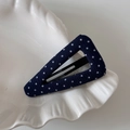 Detailed macro view of the navy blue polka dot fabric triangular snap hair clip on a dish - Navy Blue Polka Dot - Triangle