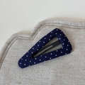 Close-up of navy blue polka dot fabric wrapped BB hair clip on a textured linen cloth - Navy Blue Polka Dot Triangle BB Clip