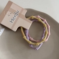 Detalle de tres gomas elásticas para el pelo de colores suaves con textura trenzada - Amarillo & Púrpura