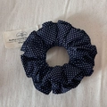 Detail of deep blue polka dot scrunchie with pleated fabric texture and elastic design - Navy Blue Polka Dot (Large)