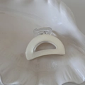 Macro shot of cream-colored claw clip with transparent handle on shell tray - Creamy White Small Semicircle