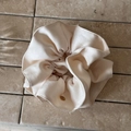 Detail of cream oversized satin scrunchie with a round golden brand logo charm - Off-White (Gold Logo)