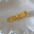 Detalle de la pinza para el pelo de acetato amarillo con lazo sobre un plato de cerámica - Amarillo