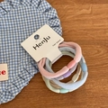 Close-up of macaron-colored elastic hair bands with smooth beads on a display card - Terry Loop