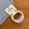 Close-up of pastel elastic hair ties set in purple yellow and green with wavy texture - Braided Thick Texture