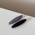 Detailed close-up of navy plaid fabric hair clip and black textured hairclip set - Checkered Navy Oval Clips